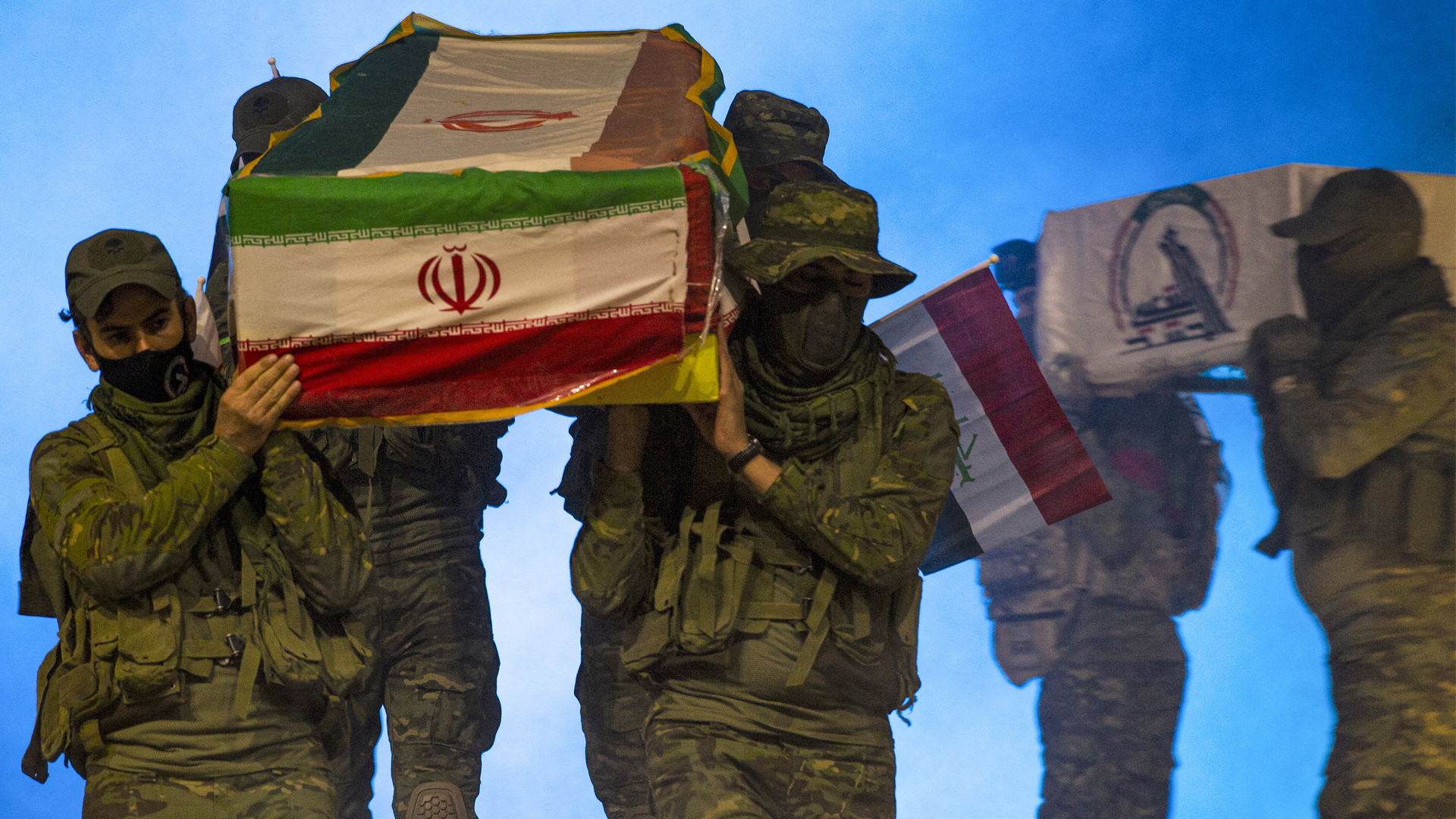 Actors carry coffins draped in the flags of Iran, Iraq, and the Hashed al-Shaabi, a former coalition of paramilitary groups, Dec. 29, 2021. (Photo: Hussein Faleh/AFP)